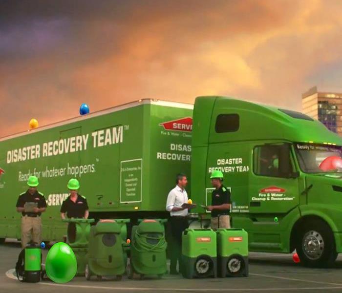 The SERVPRO team setting up equipment in front of a SERVPRO semi trailer